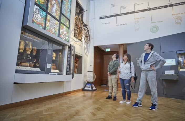 3 people looking at mosaic window